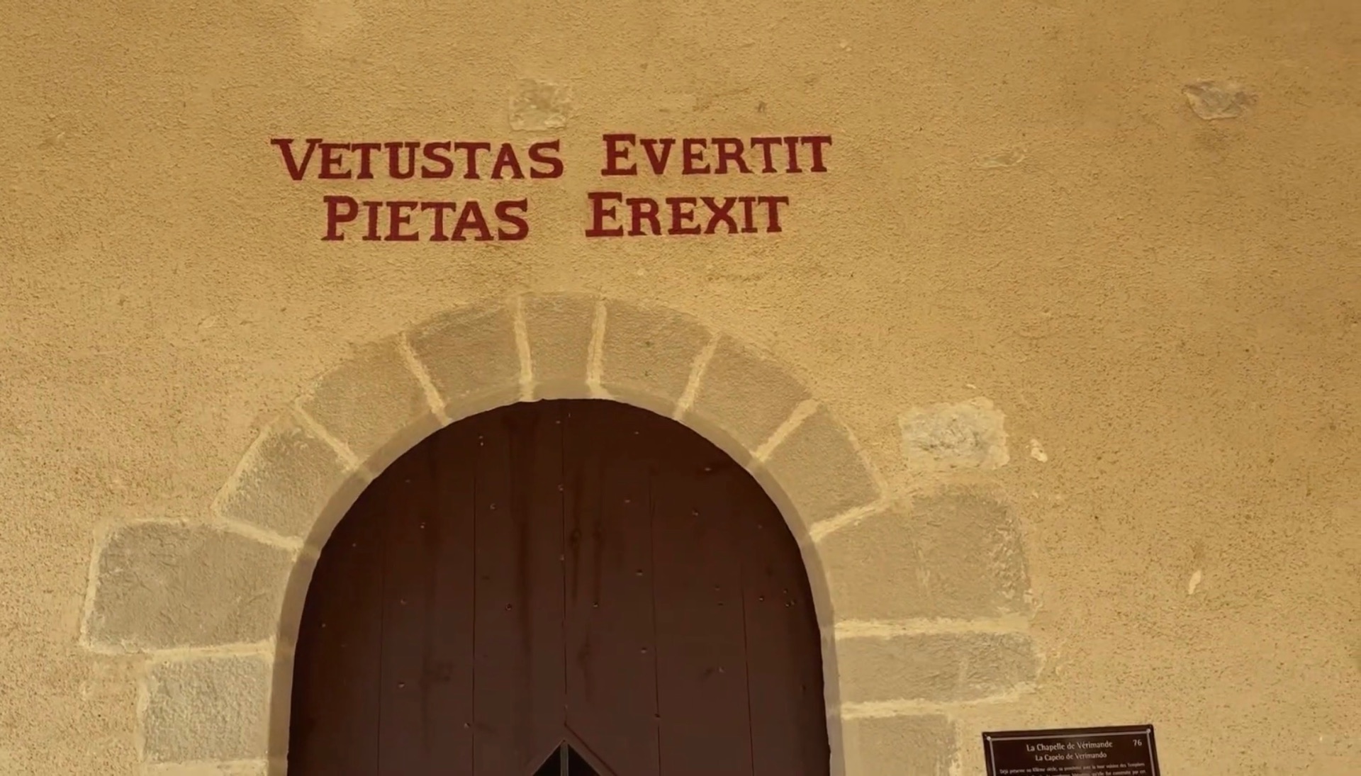 Inscription latine « Vetustas evertit, pietas erexit » au-dessus de la porte de la chapelle