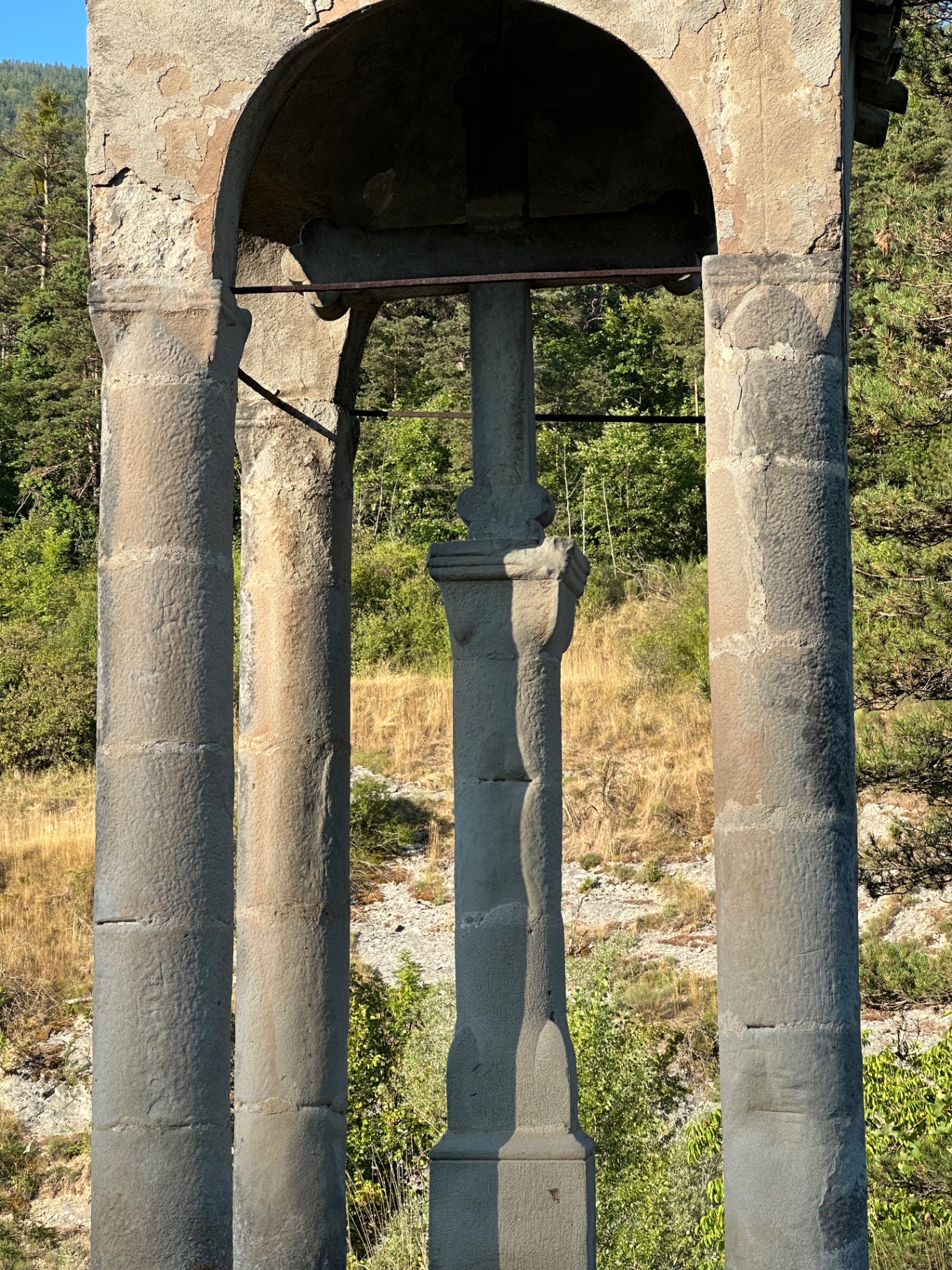 Détail de la croix de grès sculptée abritée sous l'arc du baldaquin