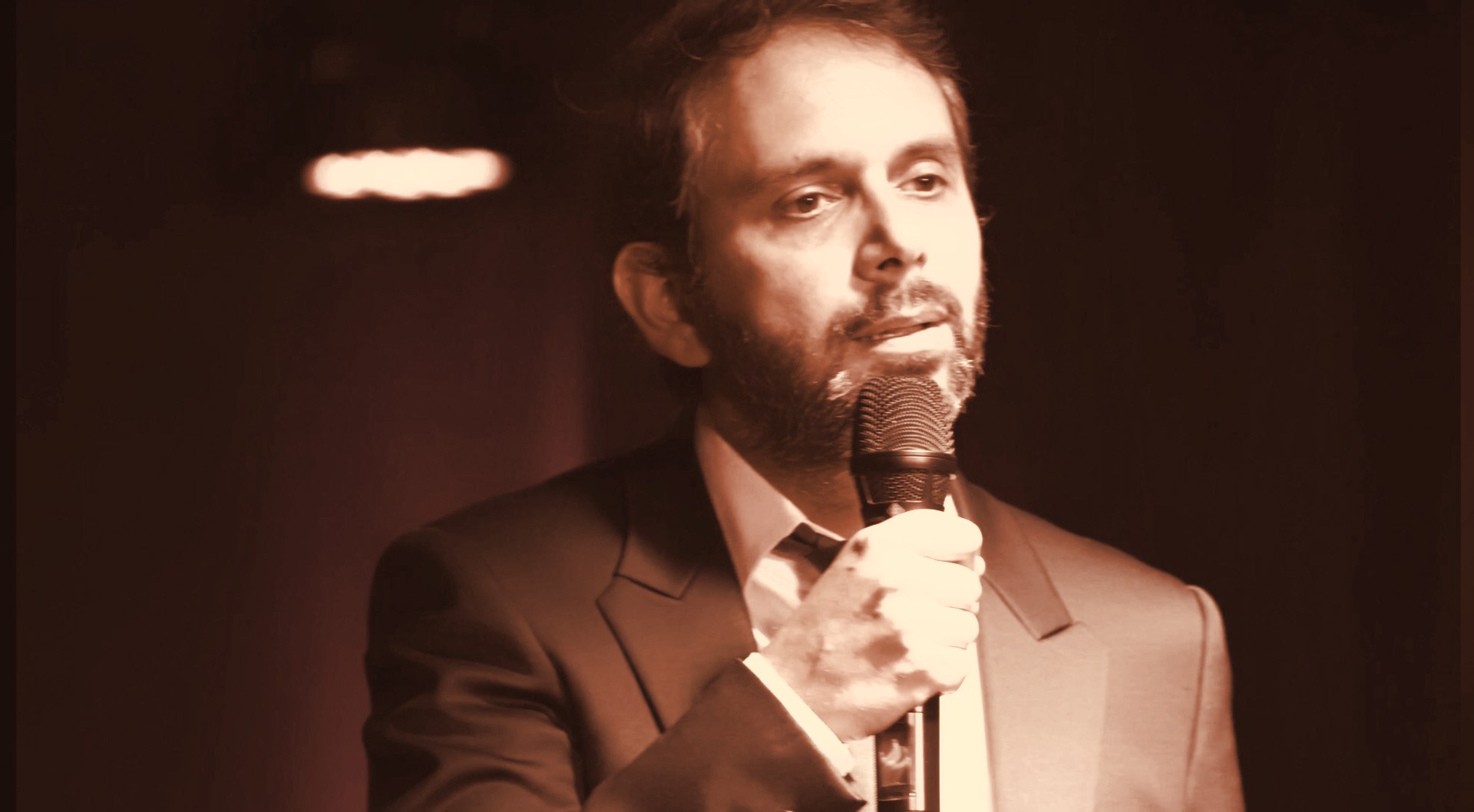 Portrait de François Anto en scène, micro à la main